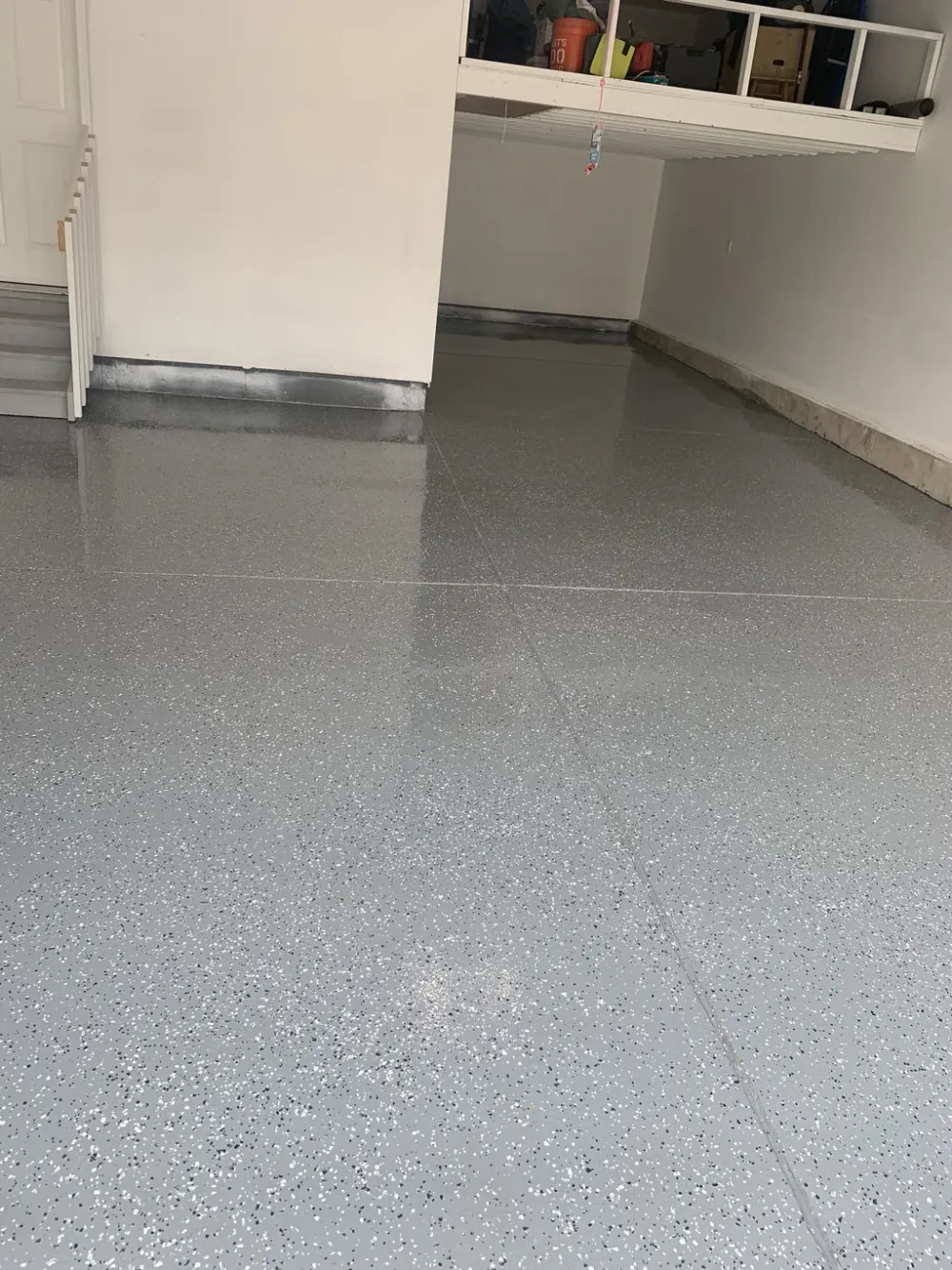 Polyaspartic top coat over a flake floor, high-gloss finish reflecting window light