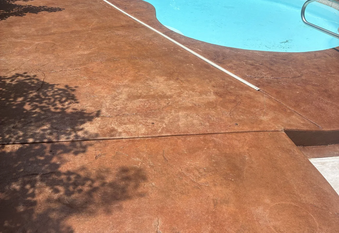 Residential pool deck after staining terracotta red and sealing with an acrylic top coat