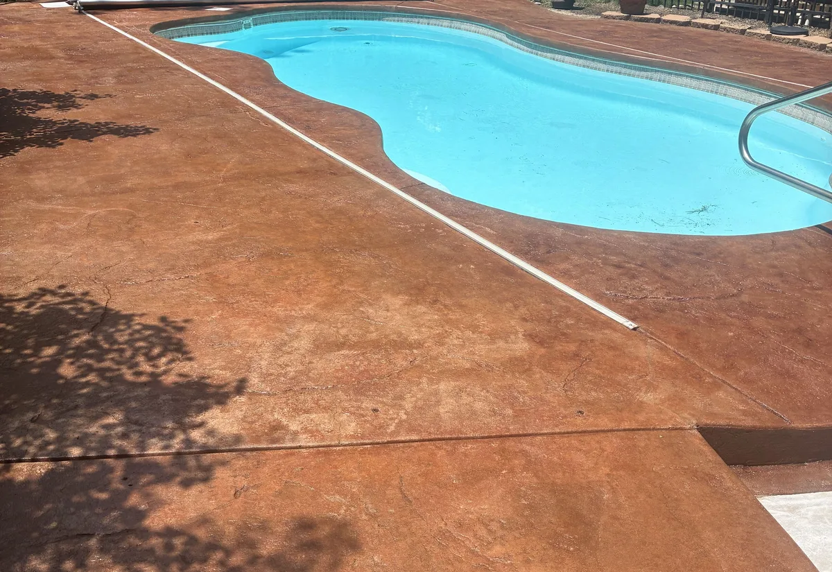 Residential pool deck stained terracotta red and sealed with an acrylic top coat
